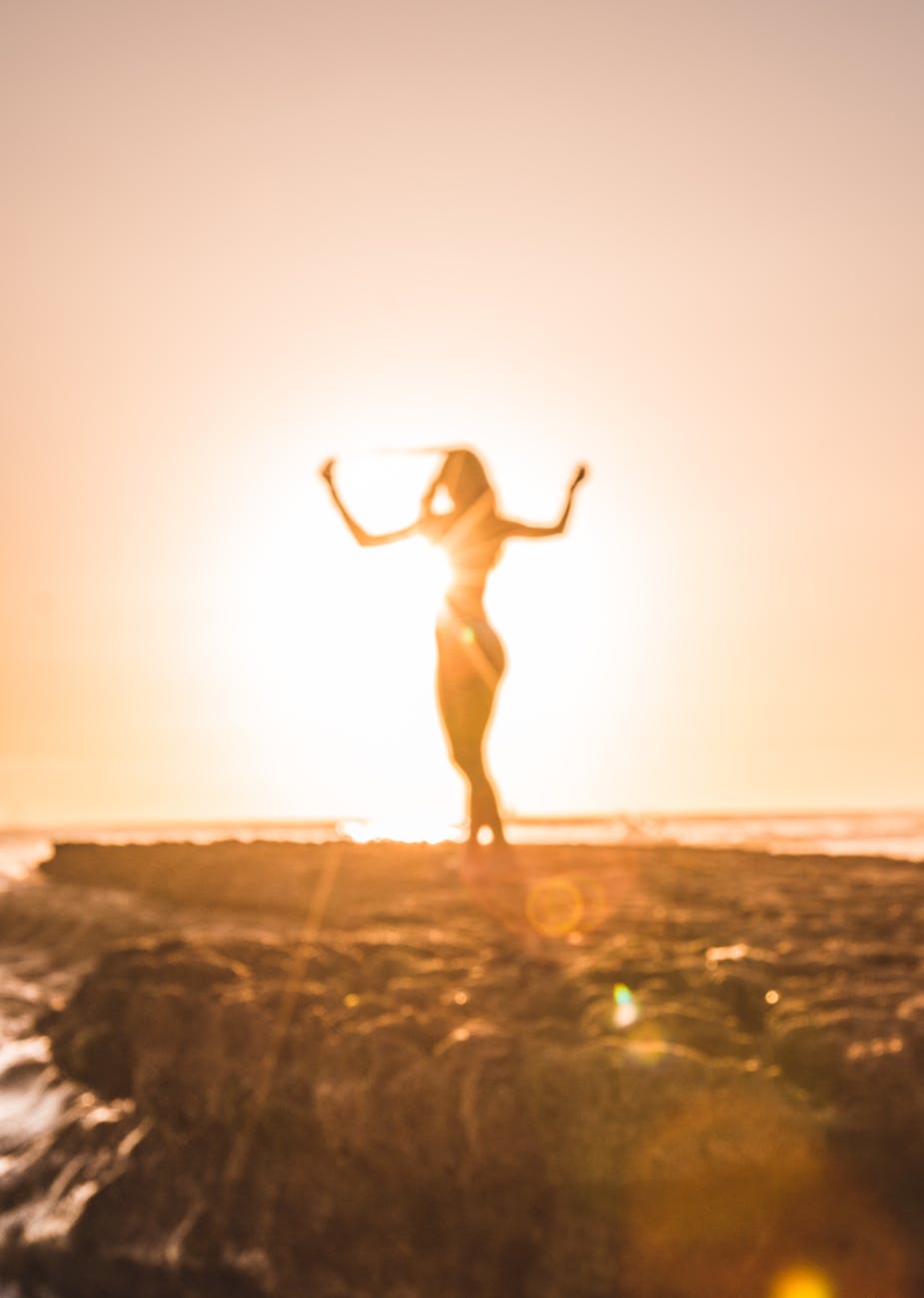 silhouette of a woman on the beach savoring the moment